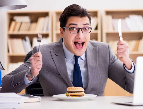 Hungriger, lustiger Geschäftsmann isst Junkfood-Sandwich — Stockfoto