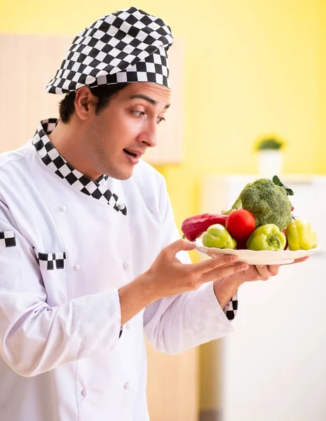 Молодой профессиональный повар готовит салат на дому — стоковое фото