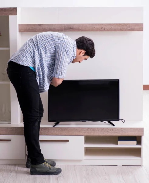 Man trying to fix broken tv