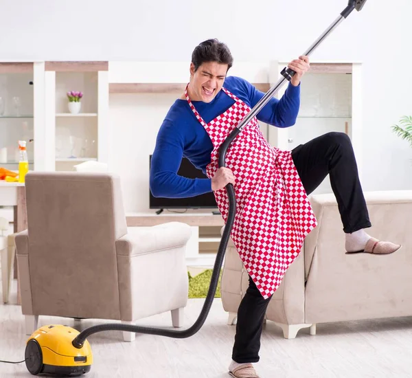 Joven hombre aspiradora limpieza de su apartamento — Foto de Stock