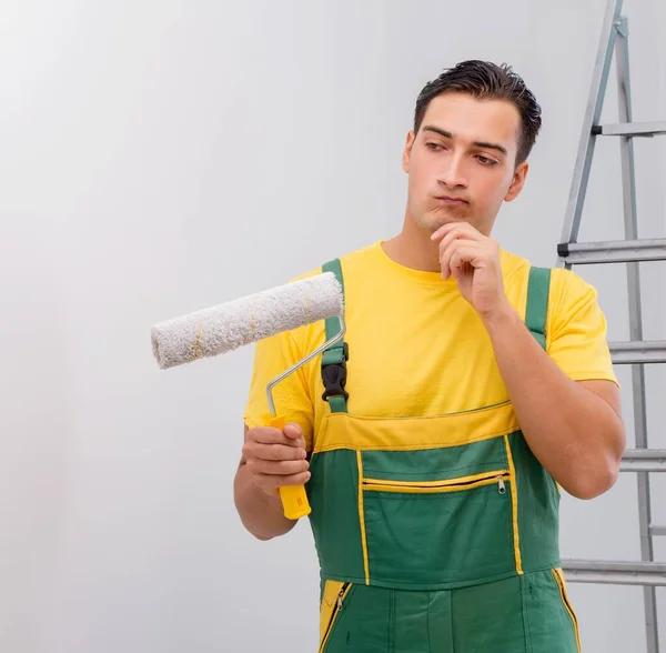 Uomo che dipinge il muro nel concetto di fai da te — Foto Stock