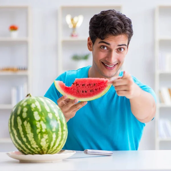 Man die thuis watermeloen eet — Stockfoto