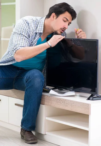 Joven marido reparando tv en casa — Foto de Stock