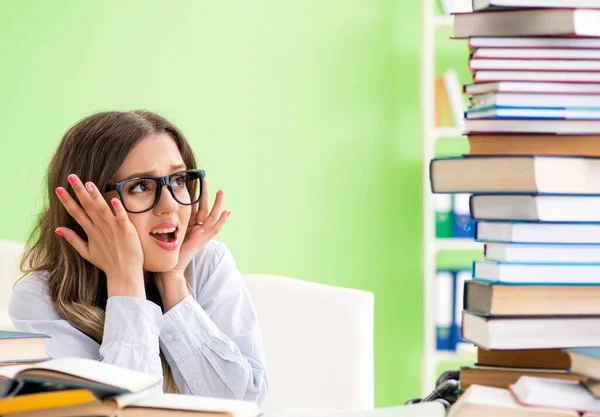 Jonge vrouwelijke student bereidt zich voor op examens met veel boeken — Stockfoto