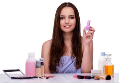 Beyazlar içinde makyaj yapan kadın.