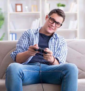 Genç adam evde bilgisayar oyunu oynuyor.