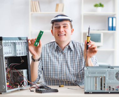 Genç teknisyen atölyede bilgisayar tamir ediyor.