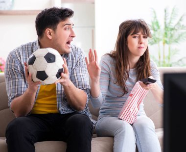 Evde futbol izleyen aile çifti.