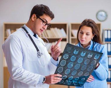 Genç doktor bilgisayardaki röntgen görüntülerine bakıyor.