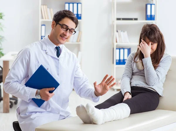 Dokter onderzoekt patiënt met gebroken been — Stockfoto