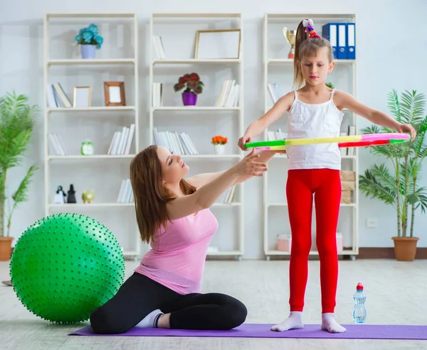 Menina e mãe se exercitando em casa — Fotografia de Stock
