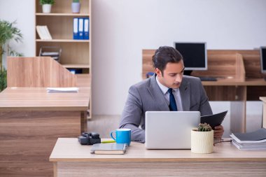 Ofiste çalışan genç bir erkek.