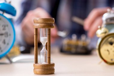 Genç erkek saatçi atölyede çalışıyor.