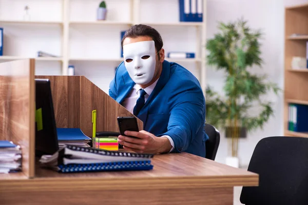 Νεαρός υπάλληλος με μάσκα στο γραφείο — Φωτογραφία Αρχείου