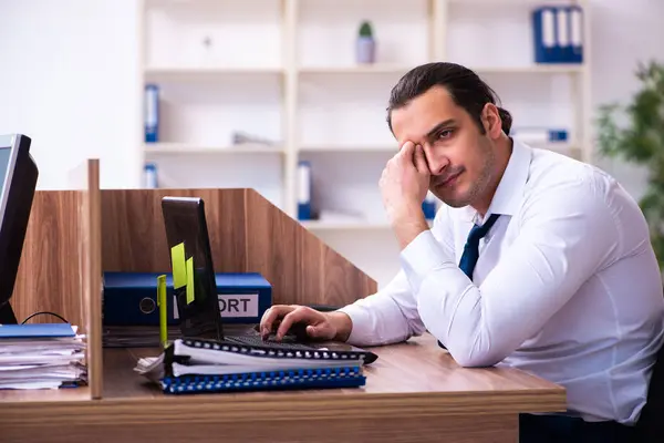 Jovem funcionário masculino infeliz com excesso de trabalho no escritório — Fotografia de Stock