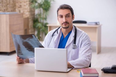 Klinikte çalışan genç erkek doktor.