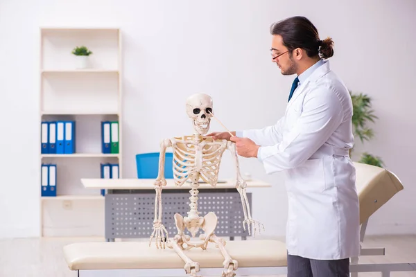 Jovem médico masculino com esqueleto — Fotografia de Stock