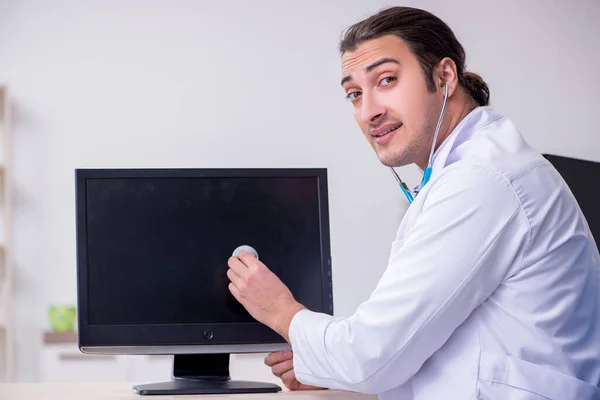 带听诊器修理计算机的年轻男医生 — 图库照片