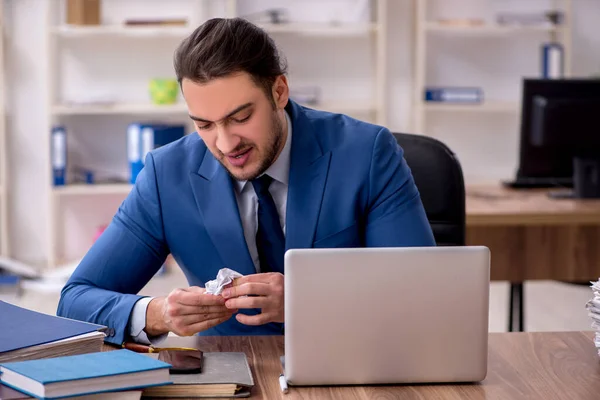 Joven empleado masculino infeliz con el trabajo excesivo —  Fotos de Stock