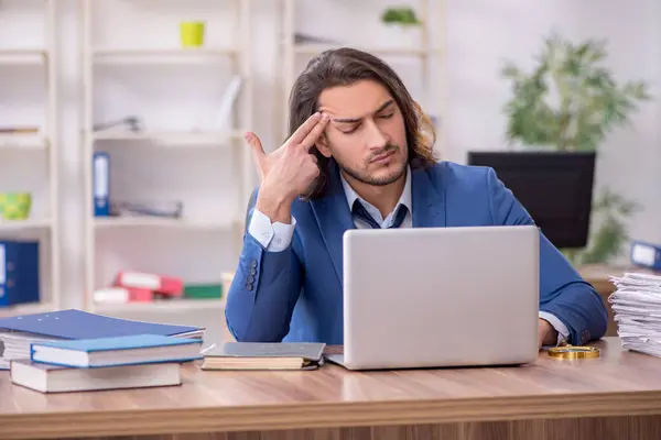 Jovem funcionário do sexo masculino infeliz com trabalho excessivo — Fotografia de Stock