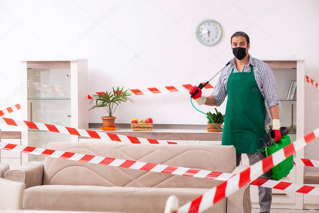 Young male sanitizer disinfecting indoors