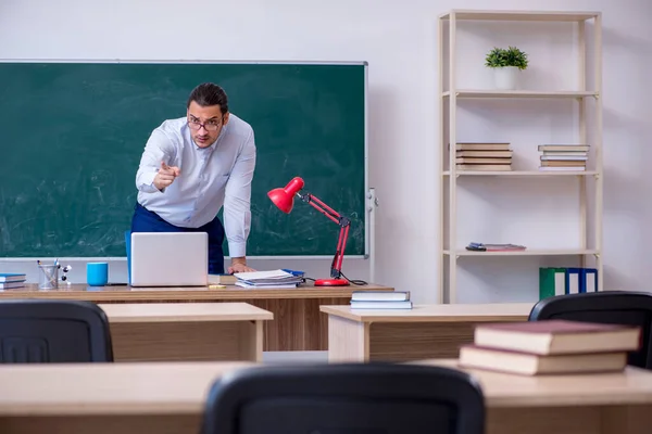 Jonge mannelijke leraar in de voorkant van groene boord — Stockfoto