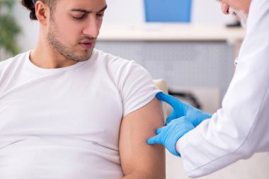 Genç adam deneyimli doktor dermatoloğu ziyaret ediyor.
