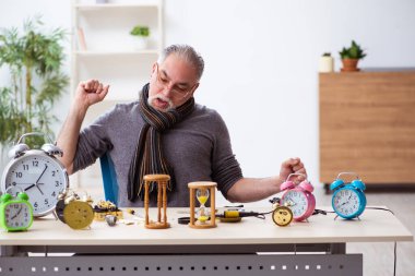 Atölyede çalışan yaşlı bir erkek saatçi.