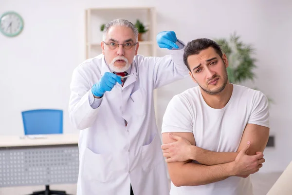 Junger Mann besucht erfahrenen Dermatologen — Stockfoto