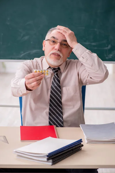 Gammal manlig lärare i klassrummet — Stockfoto