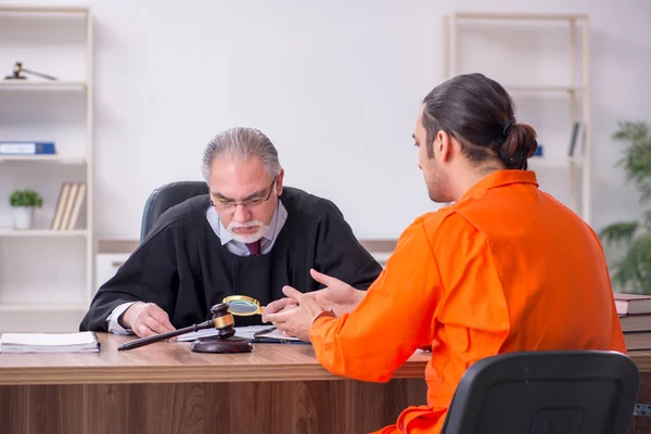 Vecchio giudice uomo incontro con giovane prigioniero in tribunale — Foto Stock