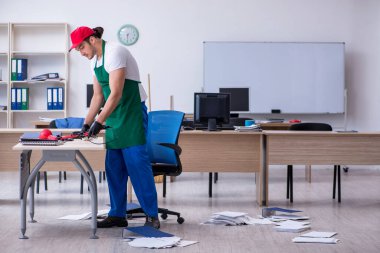 Genç müteahhit ofisi temizliyor.