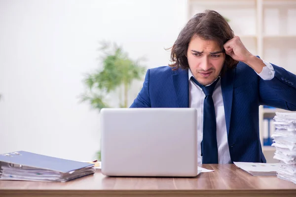 Joven empleado masculino infeliz con el trabajo excesivo — Foto de Stock