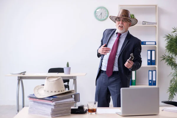 Lustige alte Chefin mit Cowboyhut im Büro — Stockfoto