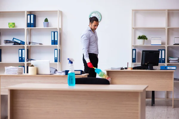 Young male employee cleaning office during pandemic — Stock Photo, Image