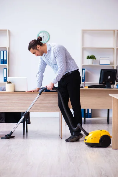 Young male employee cleaning office during pandemic — Stock Photo, Image