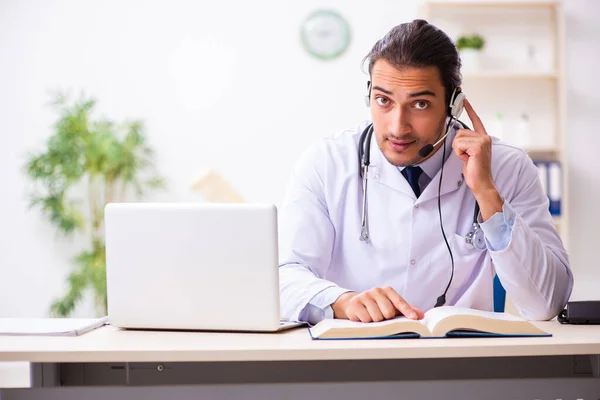 Junger Arzt hört Patient während telemedizinischer Sitzung zu — Stockfoto