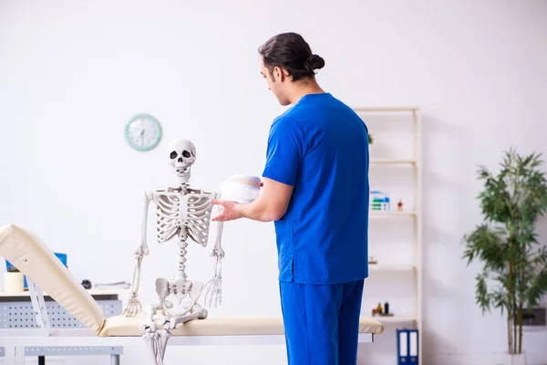 Joven profesor médico masculino demostrando esqueleto — Foto de Stock