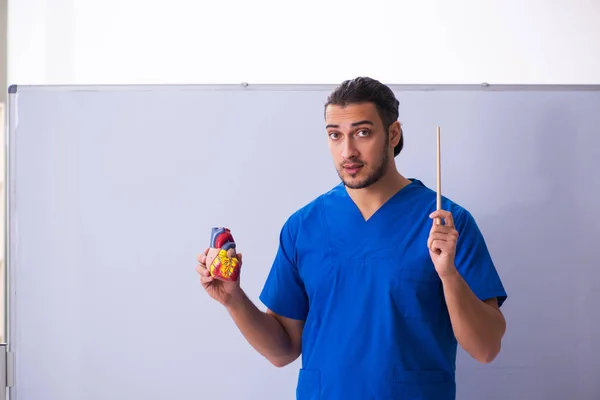 Jonge mannelijke arts leraar cardioloog in de voorkant van whiteboard — Stockfoto