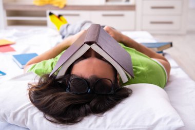 Evde sınava hazırlanan genç bir erkek öğrenci.