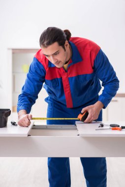 Genç erkek marangoz içeride çalışıyor.