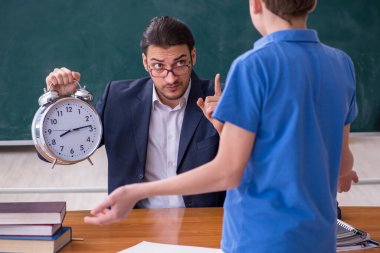 Genç erkek öğretmen ve okul çocuğu sınıfta.