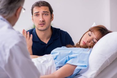 Genç koca, hasta karısını klinikte ziyaret ediyor.