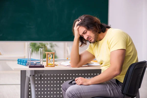 Jonge mannelijke student natuurkundige voorbereiding voor examens in de klas — Stockfoto