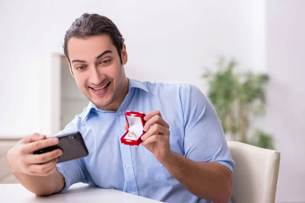 Young happy man with smartphone doing marriage proposal — Stock Photo, Image
