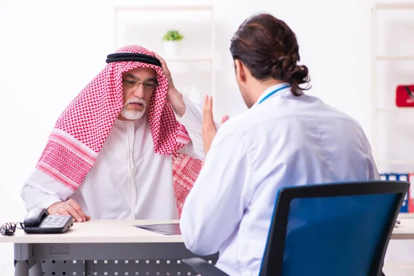 Old male arab visiting young male doctor — Stock fotografie