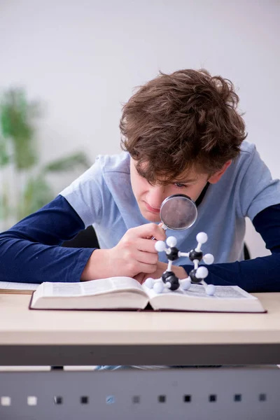 Schooljongen kijkt thuis naar moleculair model — Stockfoto