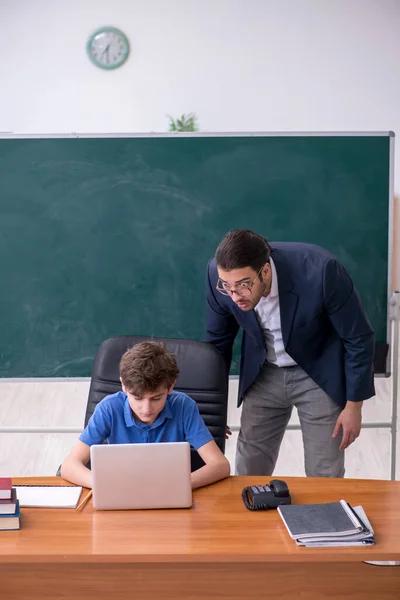 Giovane insegnante e scolaro maschio in classe — Foto Stock