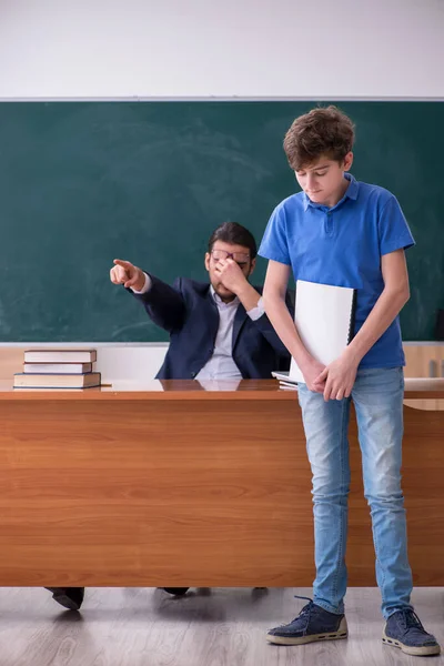 Jeune enseignant et écolier dans la salle de classe — Photo