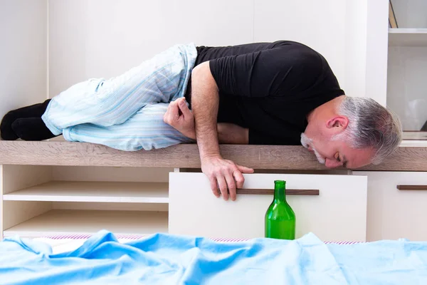 Old man drinking wine in the bedroom — Stock Photo, Image